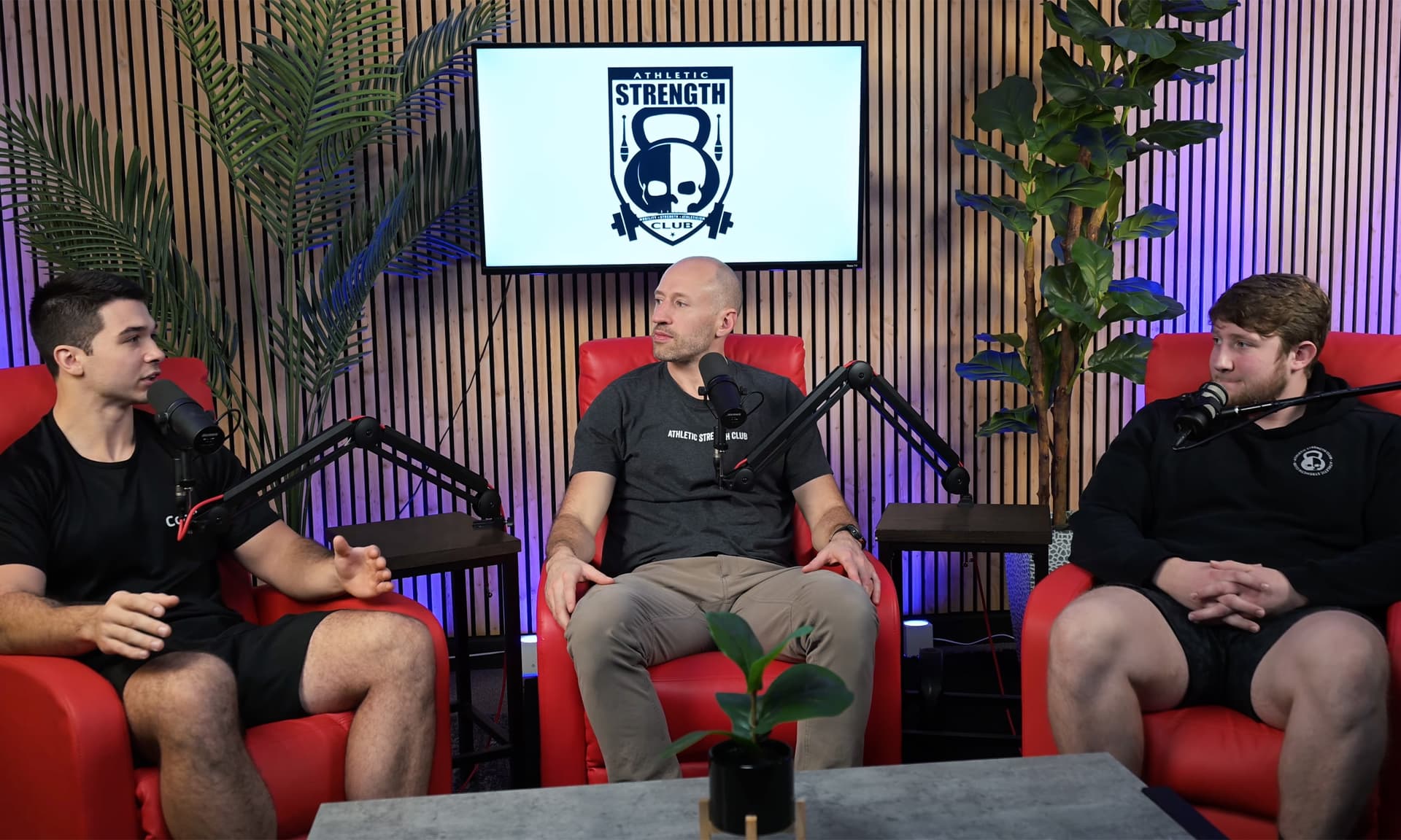 Three-person podcast session on the red chair set